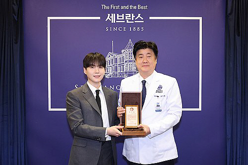 그룹 방탄소년단(BTS)의 슈가(왼쪽)와 금기창 연세의료원장이 기념 촬영하는 모습.<세브란스병원 제공>